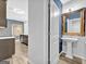 Hallway view to bathroom boasting pedestal sink, framed mirror, and stylish fixtures at 488 Jefferson Chase St, Atlanta, GA 30354