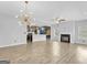 Open living room with wood floors, a fireplace, modern lighting, and a view into the kitchen area at 488 Jefferson Chase St, Atlanta, GA 30354