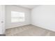 Bedroom featuring neutral carpet and crisp white walls with natural light coming from the window at 1033 Claas Way, Locust Grove, GA 30248