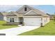 This single-Gathering home features neutral siding, a two-car garage, and a well-manicured lawn at 1033 Claas Way, Locust Grove, GA 30248