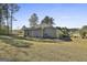 Exterior view of the back of the house showcasing a large yard and landscaping at 130 S Meadows Ridge Dr, Grantville, GA 30220