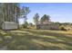 Backyard with storage shed, privacy trees, and partial view of the house at 130 S Meadows Ridge Dr, Grantville, GA 30220