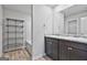 Bright bathroom featuring a double sink with granite countertops and wood-look flooring at 130 S Meadows Ridge Dr, Grantville, GA 30220