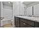 Bathroom featuring double vanity with granite countertop, dark cabinets, and a tub/shower combo at 130 S Meadows Ridge Dr, Grantville, GA 30220