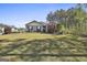 A well-manicured front yard with lush green grass, colorful shrubs, and a charming home at 130 S Meadows Ridge Dr, Grantville, GA 30220