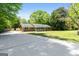 Classic brick home with a front porch and long driveway, set amidst a green lawn and mature trees at 25 Hickory Dr, Stockbridge, GA 30281