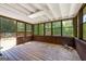 Screened-in porch with wood flooring and ceiling, dark wood siding, and many windows at 25 Hickory Dr, Stockbridge, GA 30281