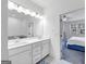 Bright bathroom featuring double sinks, white cabinetry, and an open doorway to a bedroom at 1393 Halpern Nw Ln, Kennesaw, GA 30144