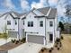 Charming two-story townhome featuring a modern design, gray garage door, and well-maintained landscaping at 1393 Halpern Nw Ln, Kennesaw, GA 30144