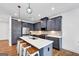 Modern kitchen features gray cabinetry, stainless appliances, an island with seating, and hardwood floors at 1393 Halpern Nw Ln, Kennesaw, GA 30144