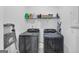 Functional laundry room with modern washer and dryer, ample shelving, and ladder at 1393 Halpern Nw Ln, Kennesaw, GA 30144