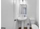 Clean powder room featuring a pedestal sink, modern toilet, and neutral decor, ideal for guests' convenience at 1393 Halpern Nw Ln, Kennesaw, GA 30144