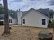 Backyard showcasing the home's exterior with a chimney and dark roof at 114 Revere Turn, Fairburn, GA 30213