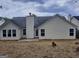 Backyard with a chimney, dark roof, white siding, and some trees at 114 Revere Turn, Fairburn, GA 30213