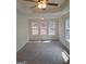 Spacious bedroom featuring a tray ceiling, ceiling fan, and three large windows at 114 Revere Turn, Fairburn, GA 30213
