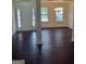 Open-concept living and dining room combo featuring dark wood floors and tons of natural light at 114 Revere Turn, Fairburn, GA 30213