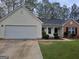 Inviting single-Gathering home with a two-car garage, neat landscaping, and a mix of brick and vinyl siding at 114 Revere Turn, Fairburn, GA 30213