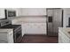 Stylish kitchen boasts stainless steel appliances, granite countertops, white cabinets, and a modern gas range at 114 Revere Turn, Fairburn, GA 30213
