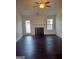 Bright living room featuring dark wood floors, a fireplace, a ceiling fan, and natural light from windows and a door at 114 Revere Turn, Fairburn, GA 30213