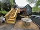 Backyard featuring a wooden deck with stairs leading to a patio, all in a wooded setting at 525 Brooksdale Dr, Woodstock, GA 30189
