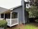 Rear exterior view of the home showcasing a white porch with mature landscaping at 525 Brooksdale Dr, Woodstock, GA 30189