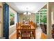 Dining room with wood floors, natural light, a table with chairs and views out to the landscaped yard at 335 Winding Stream Trl, Hampton, GA 30228
