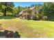 Spacious yard with a view of the home featuring stone accents, stairs and a wooded lot at 335 Winding Stream Trl, Hampton, GA 30228