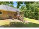 Back exterior view of home featuring a sunroom, stairs and landscaping in a private wooded lot at 335 Winding Stream Trl, Hampton, GA 30228
