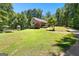 Scenic view of a ranch-style house featuring well-kept lawns and mature trees around the property at 335 Winding Stream Trl, Hampton, GA 30228