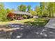 Charming ranch-style home with a detached garage and long, paved driveway surrounded by lush landscaping at 335 Winding Stream Trl, Hampton, GA 30228