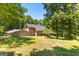 Rear exterior of home featuring a large yard and wooded area at 335 Winding Stream Trl, Hampton, GA 30228