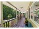Inviting covered front porch with wood railing and ample seating space overlooking a landscaped front yard at 335 Winding Stream Trl, Hampton, GA 30228
