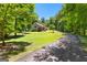 Landscaped front yard leading to a charming residence surrounded by lush trees and greenery at 335 Winding Stream Trl, Hampton, GA 30228