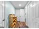 Hallway with several closet doors, wood-look floors, and a wood shelving unit at 335 Winding Stream Trl, Hampton, GA 30228