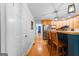 Bright kitchen with wooden stools at the island and view to the hall and pantry at 335 Winding Stream Trl, Hampton, GA 30228