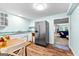 Kitchen with stainless steel fridge, white cabinets, wooden flooring and a view of the Gathering room at 335 Winding Stream Trl, Hampton, GA 30228