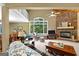 Bright living room featuring a stone fireplace, rocking chair, and large windows overlooking trees at 335 Winding Stream Trl, Hampton, GA 30228