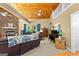 Living room with stone fireplace, wood ceiling, hardwood floors, comfortable seating and piano at 335 Winding Stream Trl, Hampton, GA 30228