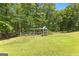 Spacious backyard featuring a playground with lush green grass and mature trees for shade at 335 Winding Stream Trl, Hampton, GA 30228