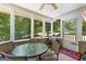 Relaxing sunroom featuring a ceiling fan, outdoor views and seating area for enjoying the wooded scenery at 335 Winding Stream Trl, Hampton, GA 30228