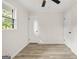 Bright bedroom features modern vinyl floors, ceiling fan, window providing natural light, and white doors at 172 W Campbellton St, Fairburn, GA 30213