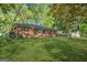 Well-maintained red brick home with a lush green lawn and mature trees surrounding the property at 172 W Campbellton St, Fairburn, GA 30213