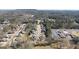 Aerial view of community, showcasing rows of homes nestled amongst the trees, and commercial buildings nearby at 2358 New Salem Trce, Marietta, GA 30064
