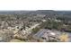 Neighborhood aerial view showing homes nestled in a wooded area, a commercial building and a nearby mountain at 2358 New Salem Trce, Marietta, GA 30064