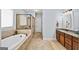 Luxurious bathroom featuring a soaking tub, separate shower, and double vanity with granite countertops at 2358 New Salem Trce, Marietta, GA 30064