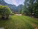 Green backyard featuring an in-ground pool and mature trees at 3650 Bay Leaf Dr, Loganville, GA 30052