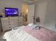 Bright bedroom featuring a light wood dresser, neutral-toned walls, and a door leading to hallway at 3650 Bay Leaf Dr, Loganville, GA 30052