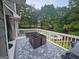 Outdoor deck with beautiful gray rug, table and furniture set with a pool and lush wooded view at 3650 Bay Leaf Dr, Loganville, GA 30052