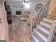 Cozy living room featuring stairs and hardwood floors, a fireplace, and comfortable seating at 3650 Bay Leaf Dr, Loganville, GA 30052