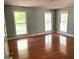 Spacious bedroom featuring hardwood floors and natural light from three large windows at 100 Parliament Ct, Fayetteville, GA 30215